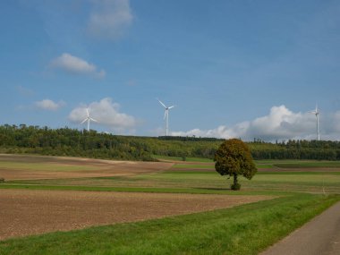 Almanya 'nın Schwaebische Alb bölgesinde güzel geniş bir manzara. Rüzgar jeneratörleri geniş bir vadinin yukarısındaki orman tepelerinde yer alıyor..