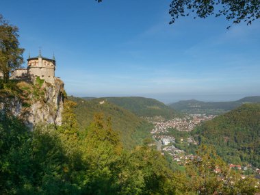 The Schwaebische Alb mountain ridge offers beautiful castles and fortifications. Situation of Lichtenstein castle, situated on a steep rock high above the valley clipart