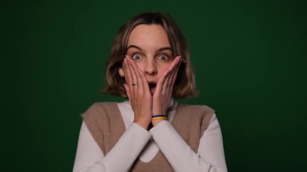 Удивлённая Взволнованная Молодая Женщина Удивлением Поднимает Руки Смотрит Камеру Зеленом — стоковое видео
