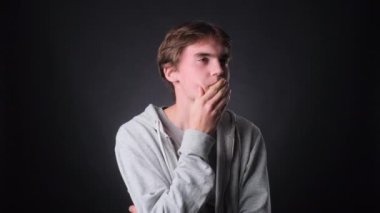 Kafkasyalı genç bir adam, gelişigüzel giyinmiş, tarafsız bir siyah arka plana karşı parlak bir fikirle çarpışıyor. Onun ilham verici ifadesi ve düşünceli davranışı yeniliğin heyecanını iletir..