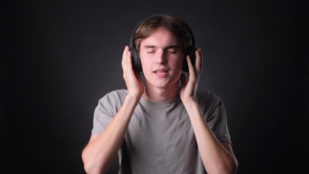 Young Man Dressed Casually Listens Music Headphones Dances Joy Neutral — Stock Video