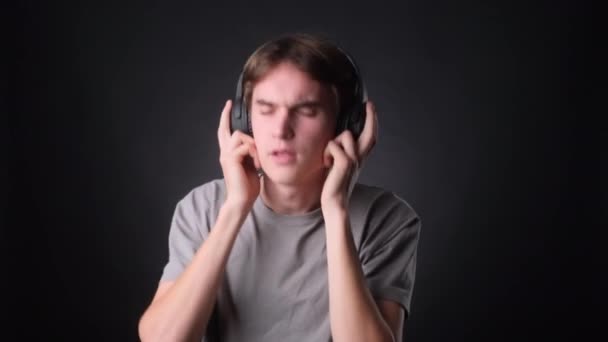 Contented Man Dressed Casually Enjoying Music Headphones Serene Black Backdrop — Stock Video