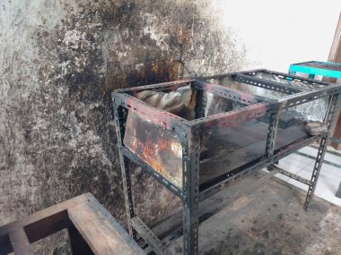 Tüccarın kirli gözüktüğü masa, delinmiş bir demir çerçeveden yapılmıştır.