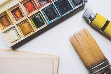 Sanat işyerinin üst görüntüsü, suluboya palet, fırça, çarşaf, boya tüpü
