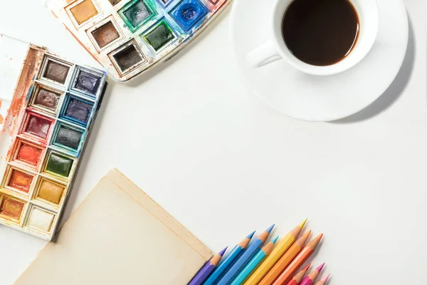 Sanat işyeri, suluboya palet ve renkli kalemler.