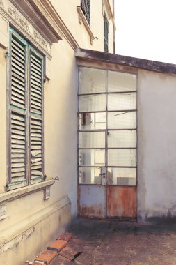 Klasik stil çürümesi olan eski bir bina. Cam kapılı giriş, dış yüzey.