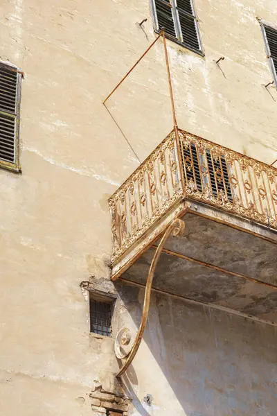 Detail of ruined big building, balcony with wrought iron railing, view from below