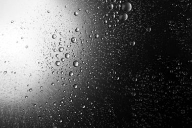 Su gölgeli bir yüzeye düşer, siyah ve beyaz. 