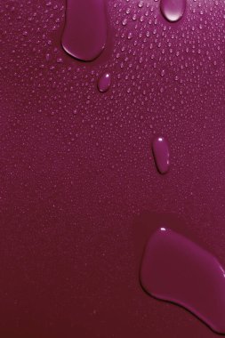 Su damlalarıyla yüzey, kırmızı arkaplan