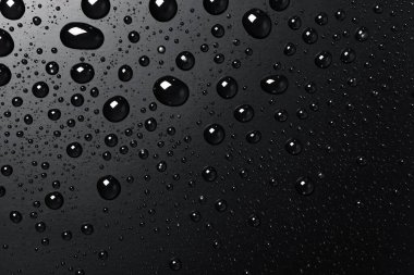 Su siyah bir yüzeye düşer, soyut bir arkaplan
