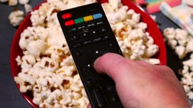 Televizyon kumandalı, patlamış mısır arka planda 4k yavaş çekim seçici odaklanma.