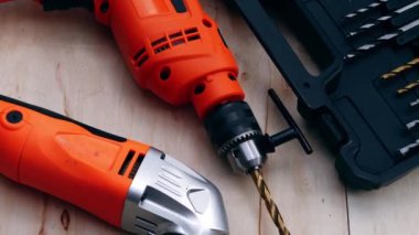 Electric power drill and sander on wooden background medium dolly shot selective focus