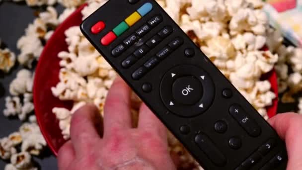Ruka Televizním Dálkovým Ovládáním Popcorn Pozadí Zpomalení Zblízka Selektivní Zaměření — Stock video