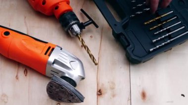 Joiner, tahta arka planda zımpara matkabı ile elektrikli matkap uçlarını alır. 4k kule görüntüsü seçici odak noktası