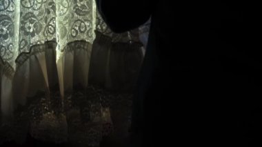 Endişeli kadın net perdelerden bakıyor. Orta derece, yavaş çekim seçici odak noktası.