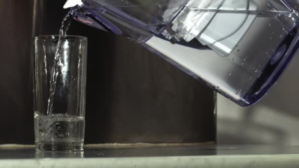 水フィルターから水のガラスを注ぐ女性中出しスローモーション4K選択的フォーカス — ストック動画
