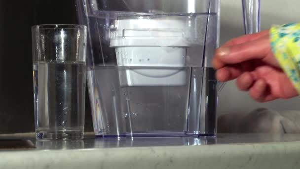女人从滤水罐里拿杯水中弹慢镜头缩放选择性焦距 — 图库视频影像