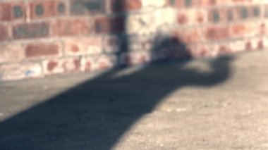 Shadow of woman waving on brick building background medium slow motion shot selective focus