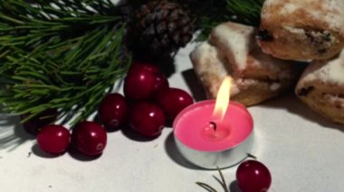 Christmas cake Stollen with cranberries and candle close up selective focus