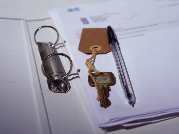 Key with paperwork and pen for property medium shot selective focus
