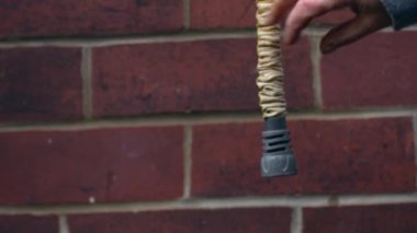 Gardener checks garden hose hangs against brick wall background medium zoom shot selective focus