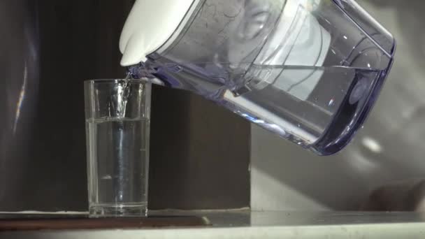 ウォーターフィルターから水のガラスを注ぐ女性中出しスローモーションズーム選択的フォーカス — ストック動画