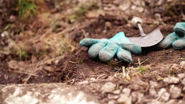 庭用手袋と土壌中のスペードのパンニングショット4K選択的フォーカス — ストック動画