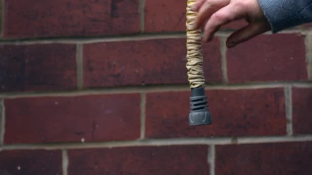 Gardener Checks Garden Hose Hangs Brick Wall Background Medium Shot — Stock Video