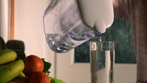 グラスの濾過水と新鮮なフルーツ中出しスローモーション4K選択的フォーカス — ストック動画