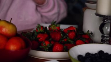 Sağlıklı meyve seçimi, arka planda yemek yiyen bir kadın yavaş çekim seçici odaklanma.