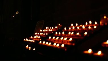 Sıralar dolusu çay ışığı mumları kilise genelinde yanıyor yavaş çekim seçici odak noktası