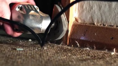 Eski kapıda elektrikli zımpara makinesi kullanan bir kadın 4K seçici odak noktasını kapat