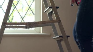 Stepladders evinin arka planına tırmanan bacaklar 4k yavaş çekim seçici odak noktası
