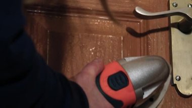 Eski kapı 4k 'de elektrikli zımpara makinesi kullanan bir kadın seçici odak noktasını yakın çekim yapar.