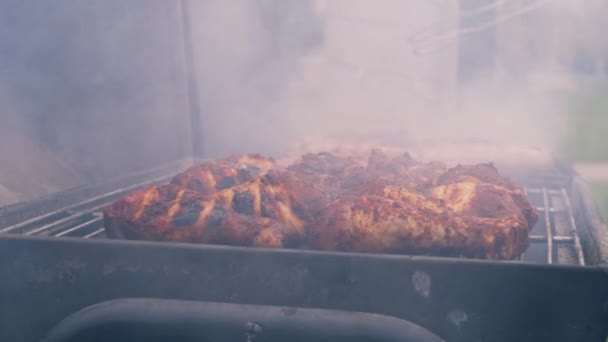 喫煙で鶏肉を調理バーベキューグリル中遅い動き4Kショット選択的フォーカス — ストック動画
