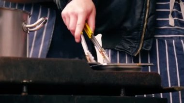 Şef kutlama etkinliğinde sıcak yemek hazırlıyor. Orta boy. Yavaş çekim seçici odaklanma.