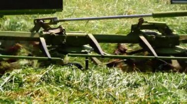 Çim biçen traktörlü yaz çayırı. Orta boy. Yavaş çekim seçici odak noktası.