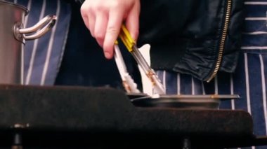 Şef kutlama etkinliğinde sıcak yemek hazırlıyor. Orta boy. Yavaş çekim seçici odak noktası.