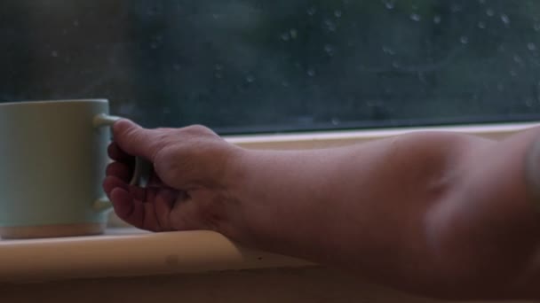 Meminum Cangkir Kopi Panas Dengan Jendela Hujan Latar Belakang Perbesaran — Stok Video