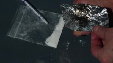 Uyuşturucu bağımlısı folyoyla eroin yakıyor. Ağır çekim 4K, seçici odaklanma gösteriyor.
