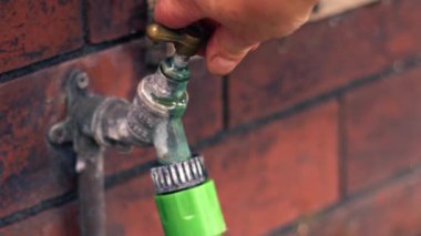 Çürük musluk bir bahçede sızdırıyor. Yakın çekim, zoom 4k seçici odaklanma.