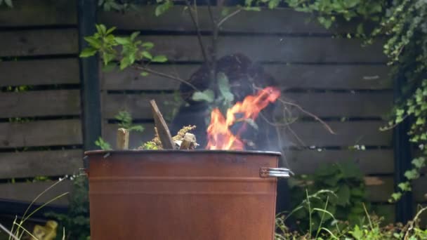 ガーデンと家のゴミは ビン焼却器で燃えています クローズアップショット4Kスローモーション選択的な焦点 — ストック動画