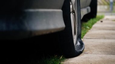 Asfaltta lastiği patlamış bir araba. 4 km yavaş çekim odaklı, seçici odaklı.