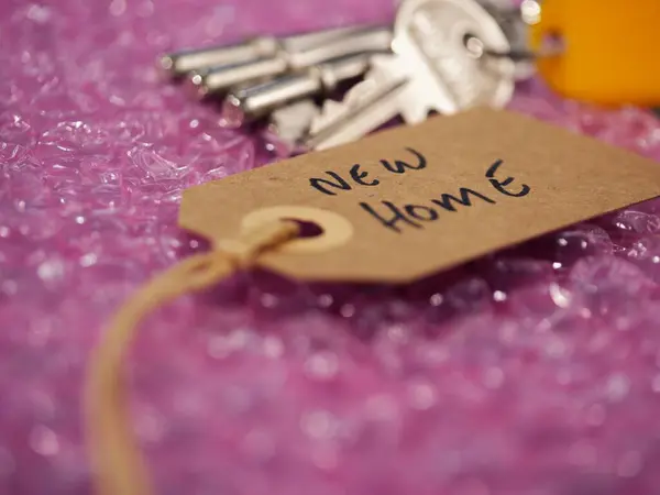 Bubble wrap and brown address label with keys to new home close up shot selective focus