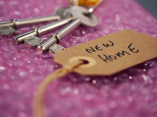 Bubble wrap and brown address label with keys to new home close up shot selective focus
