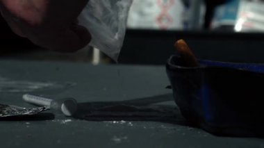Kokain hazırlayan uyuşturucu bağımlısı yavaş çekimde 4k seçici odaklanma gösteriyor