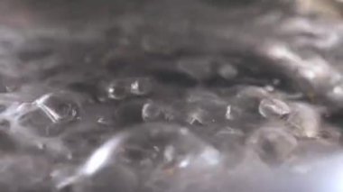 Sıcak su ağır çekimde kaynıyor. Makro çekim yakın. 4k seçici odak noktası.