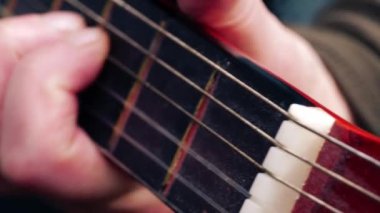 Müzisyen akustik gitar çalıyor. Yakın çekim, yavaş çekim zoom, seçici odaklanma.