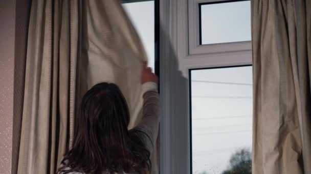 ホームウィンドウのカーテンを閉じる女性 中型ショットスローモーションズーム選択フォーカス — ストック動画