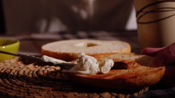 サービングベーグルパン スライスしてトースト クリームチーズトッピング 中型ズームスローモーションショット選択的な焦点 — ストック動画